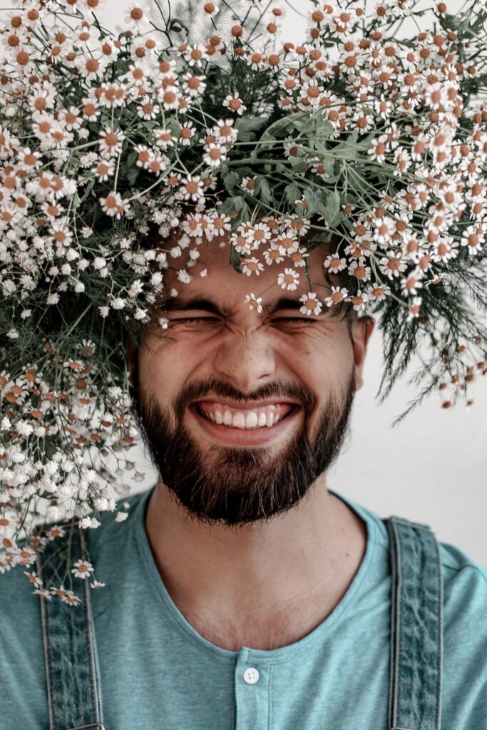 Man smiling, crowned with flowers