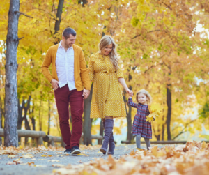 family taking a stroll in fall leaves